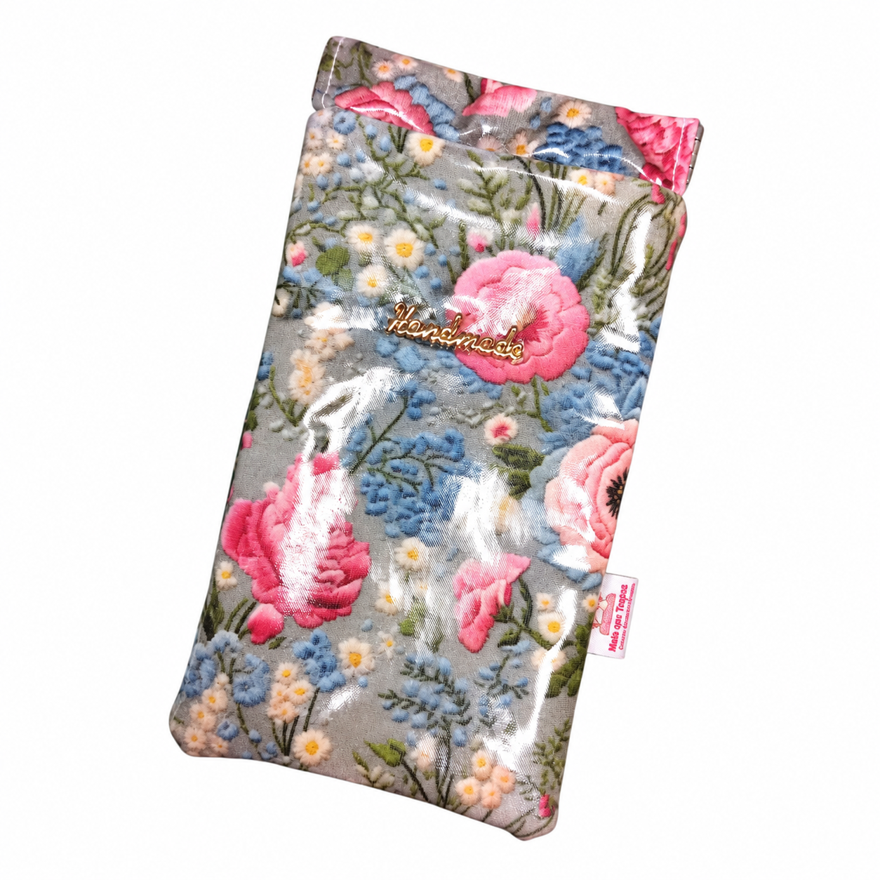 Bolsa de tecido plastificado com estampa floral azul, rosa e branca.